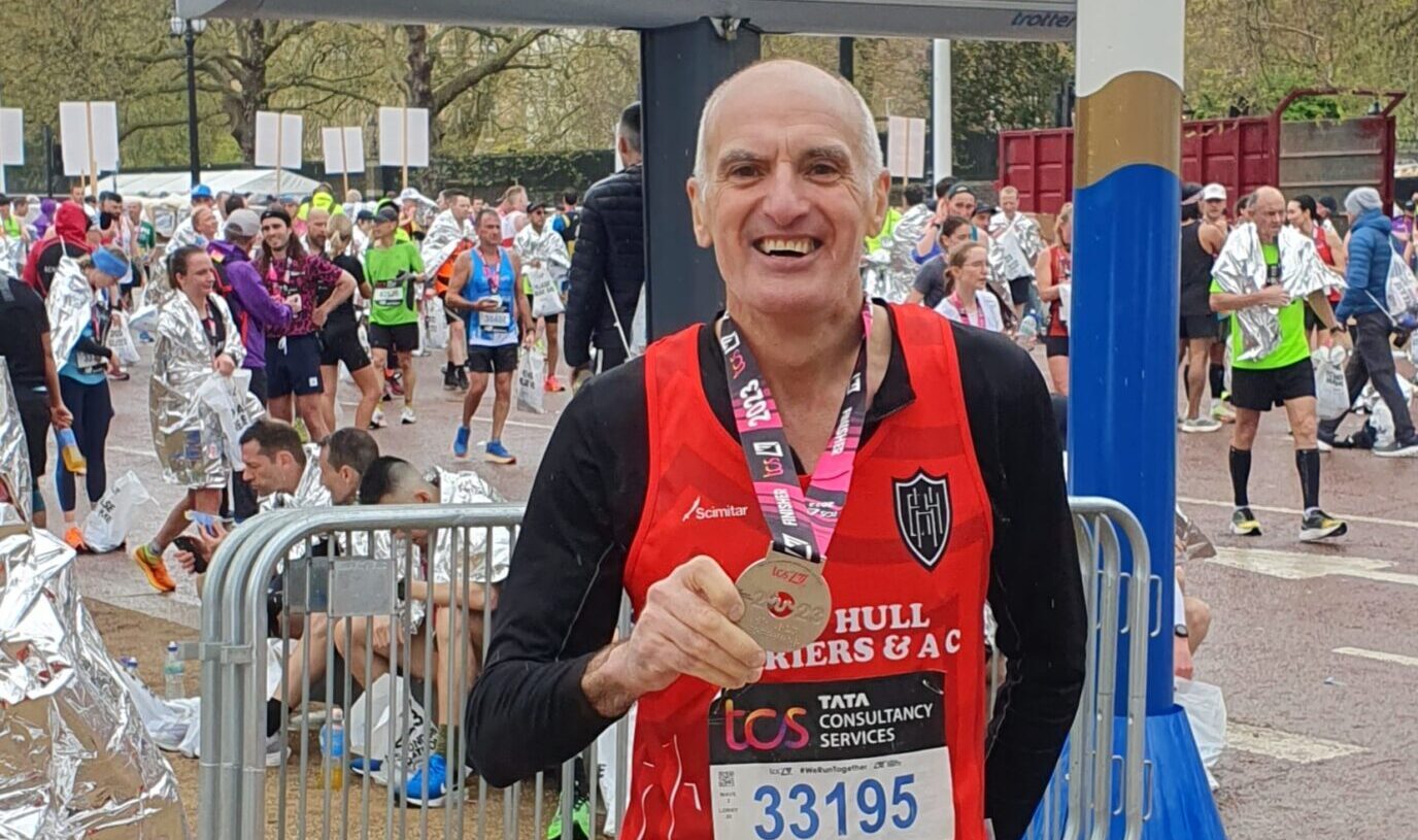 Gary Fee holding his London Marathon Medal