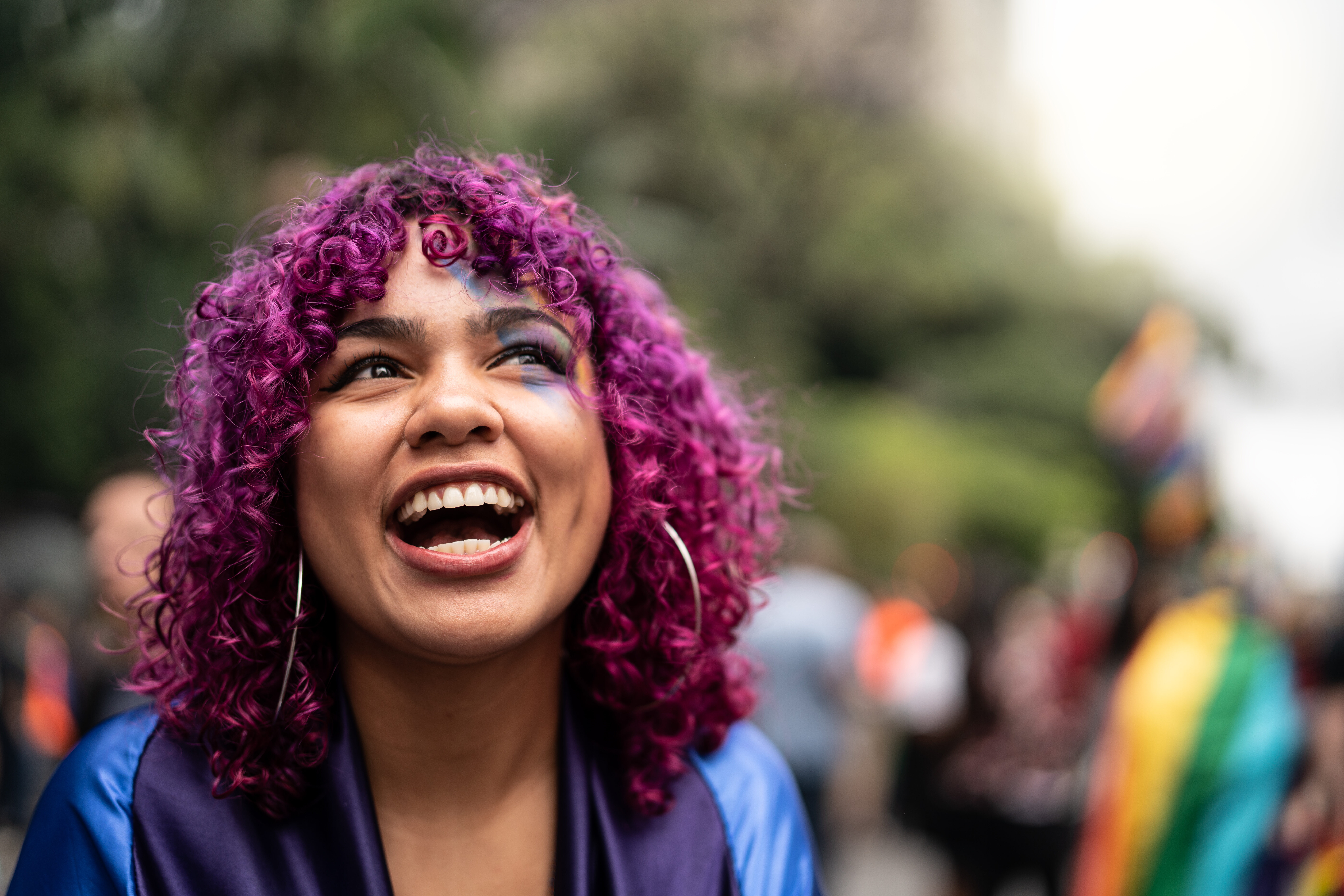 Girl with pink hair smiling broadly into the camera