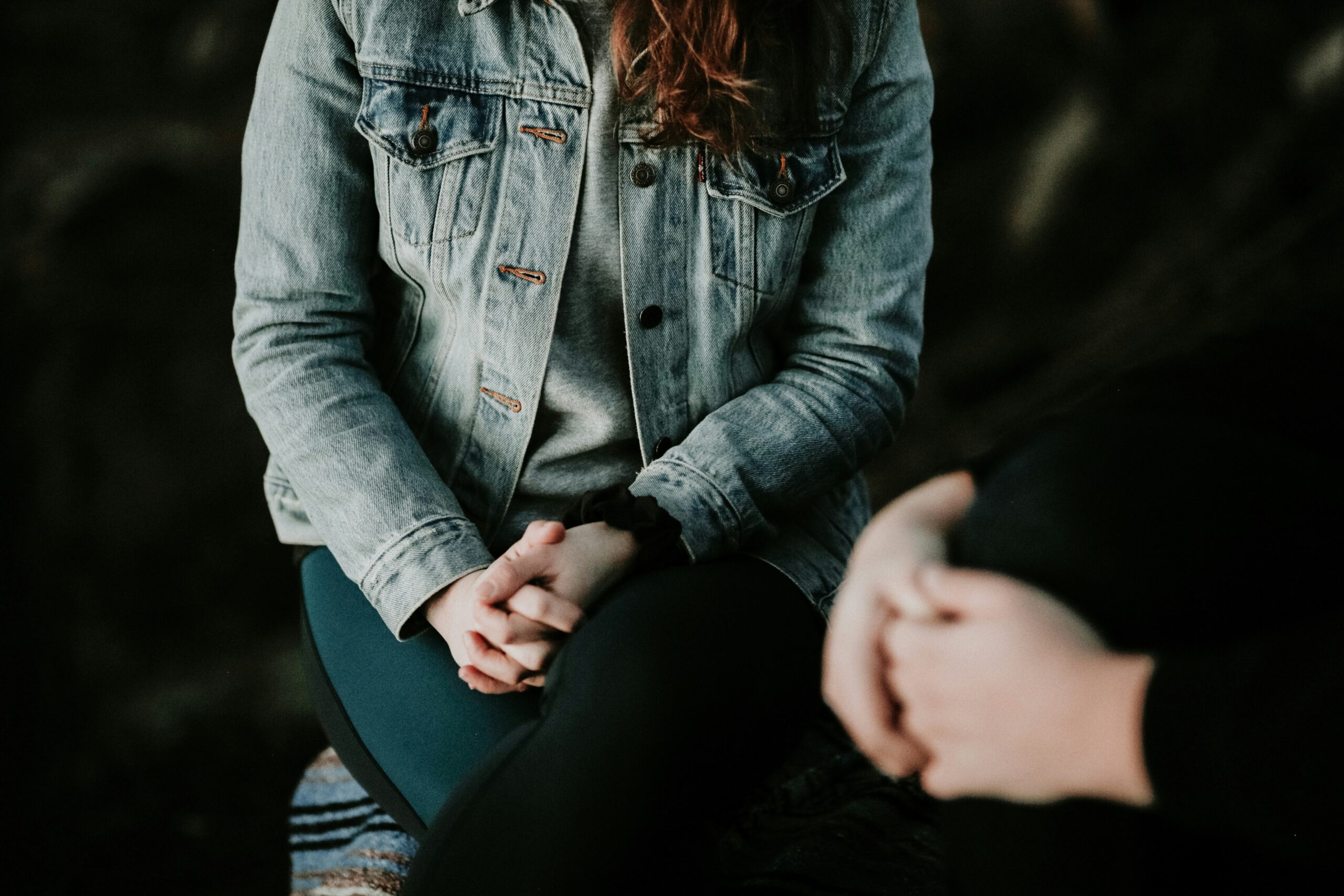 A close up of people hands sitting whilst chatting in a therapy session